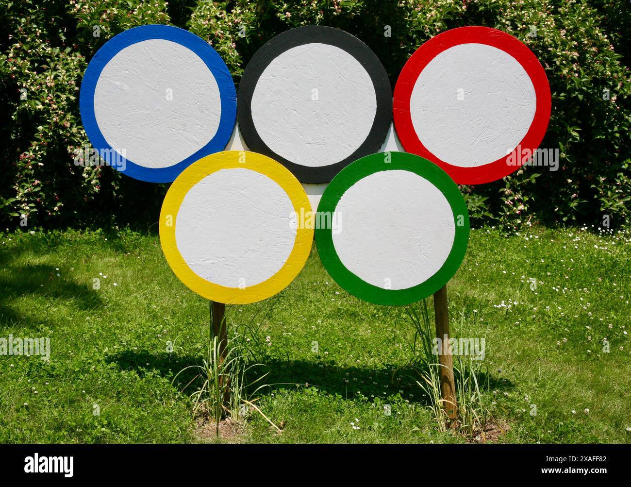 Una riproduzione rustica degli anelli Olimpici, vicino al lago, St Fraimbault, Normandia, Nord Ovest della Francia, Europa nell'estate del 2024 Foto Stock