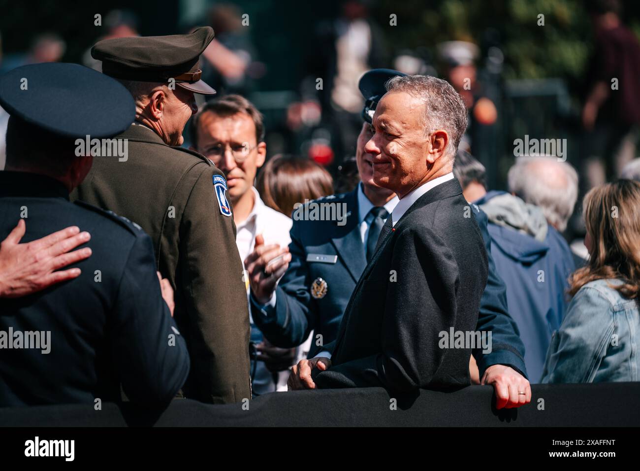 Colleville-sur-Mer, Francia. 6 giugno 2024. L'attore e regista americano Tom Hanks, Right, saluta il veterano militare durante un evento al Normandy American Cemetery, 6 giugno 2024, a Colleville-sur-Mer, in Francia. Biden si unì ad altri leader mondiali per celebrare il 80° anniversario del D-Day. Crediti: Sergente Landon Carter/US Army Photo/Alamy Live News Foto Stock