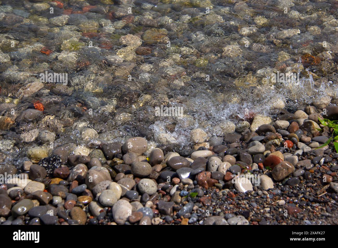 Marea su pietre in spiaggia Foto Stock