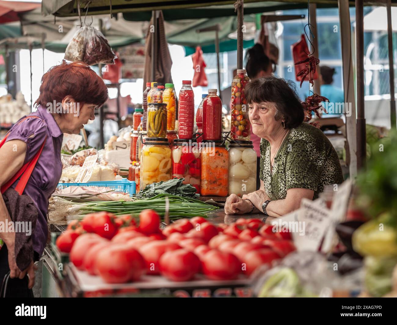 Foto di due donne che discutono, un commerciante, un cliente, nel mercato venaco di zeleni, serbia. Il mercato di Zeleni Venac è un importante mercato agricolo situato i Foto Stock