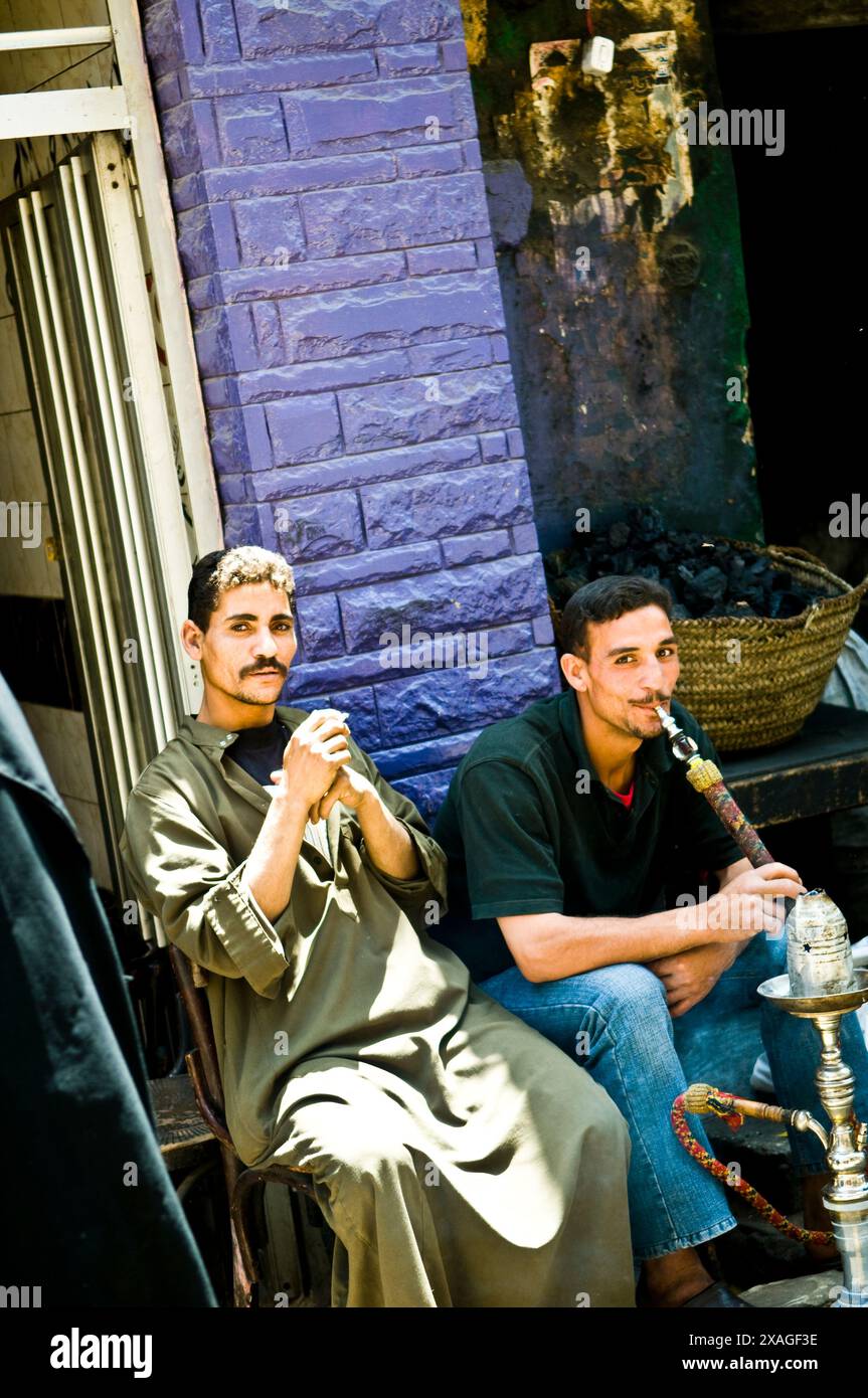 Uomini egiziani che fumano Shisha. (Tubo dell'acqua) in un piccolo caffè al Cairo, in Egitto. Foto Stock