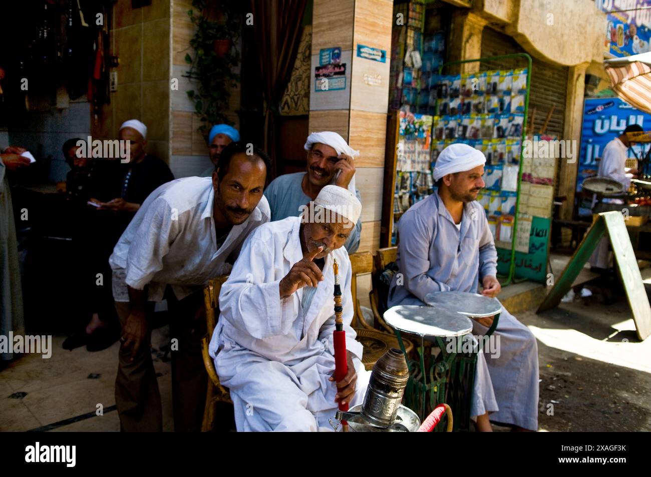 Uomini egiziani che fumano Shisha. (Tubo dell'acqua) in un piccolo caffè al Cairo, in Egitto. Foto Stock