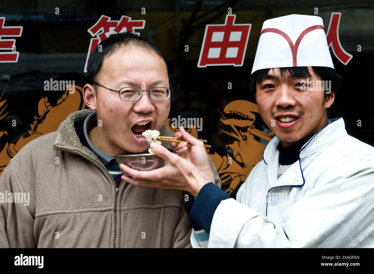 Uno chef che dà da mangiare al suo cliente. Nanchino, Cina. Foto Stock