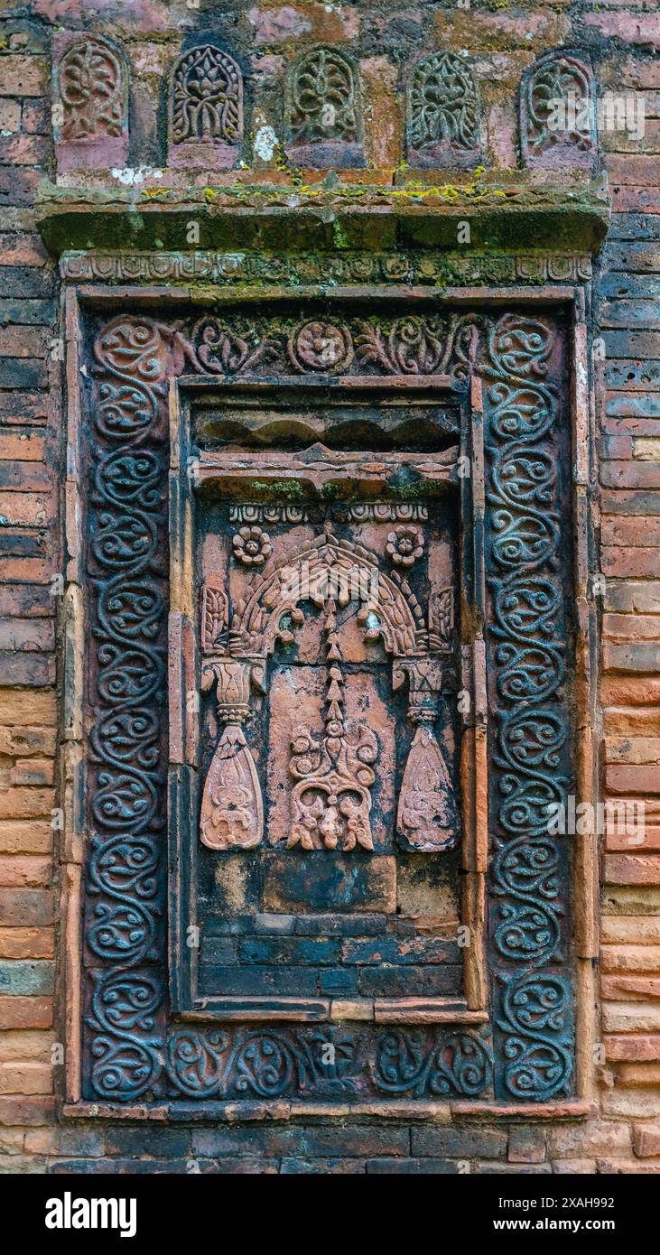 Vista verticale ravvicinata del decor in mattoni e terracotta sulla parete esterna dell'antica moschea medievale di Goaldi, Sonargaon, Bangladesh Foto Stock