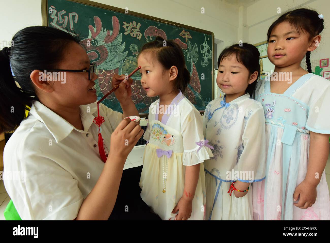 I bambini imparano le usanze popolari del Dragon Boat Festival nella città di Lianyungang, nella provincia cinese di Jiangsu, 4 giugno 2024. Foto Stock