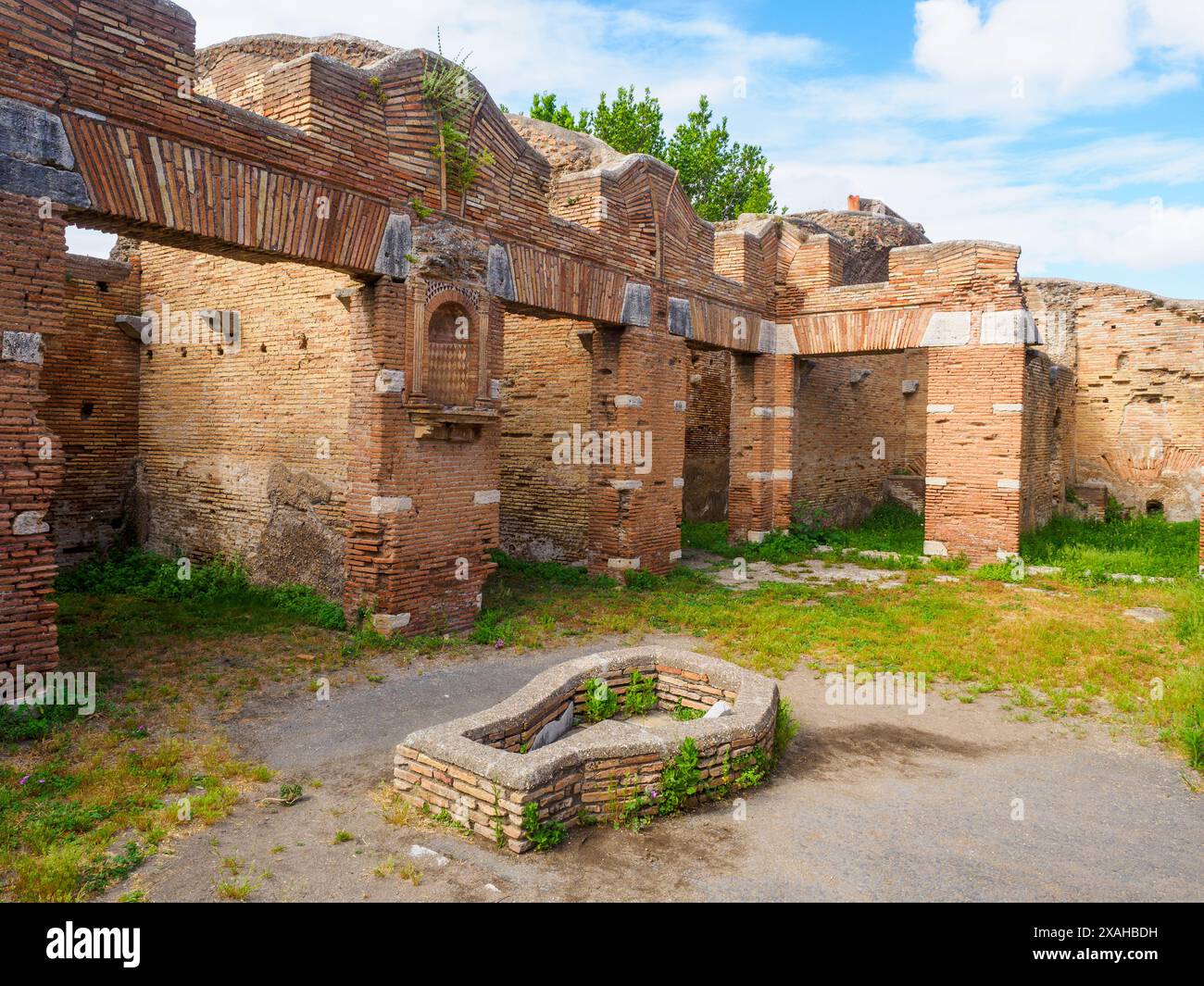 Cortile - Caseggiato del Larario - il complesso, costruito intorno al 120 d.C., fu probabilmente utilizzato per la vendita di beni di lusso come suggerito dalla sua posizione nelle immediate vicinanze del foro e dal suo aspetto particolarmente curato - Parco Archeologico di Ostia Antica, Roma, Italia Foto Stock