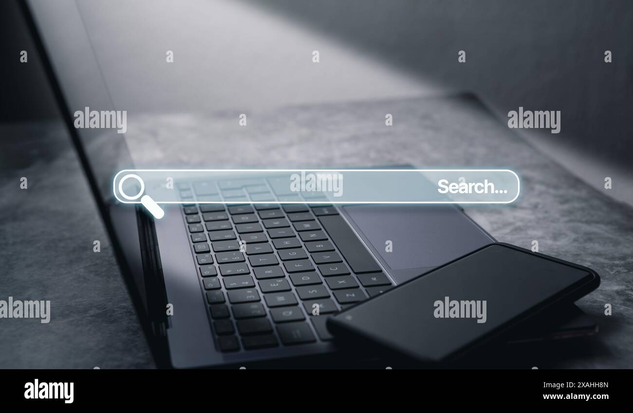 Foto desktop con laptop e smartphone con barra di ricerca olografica. Internet delle cose. Concetto di ricerca delle informazioni sui dati Internet. Foto Stock