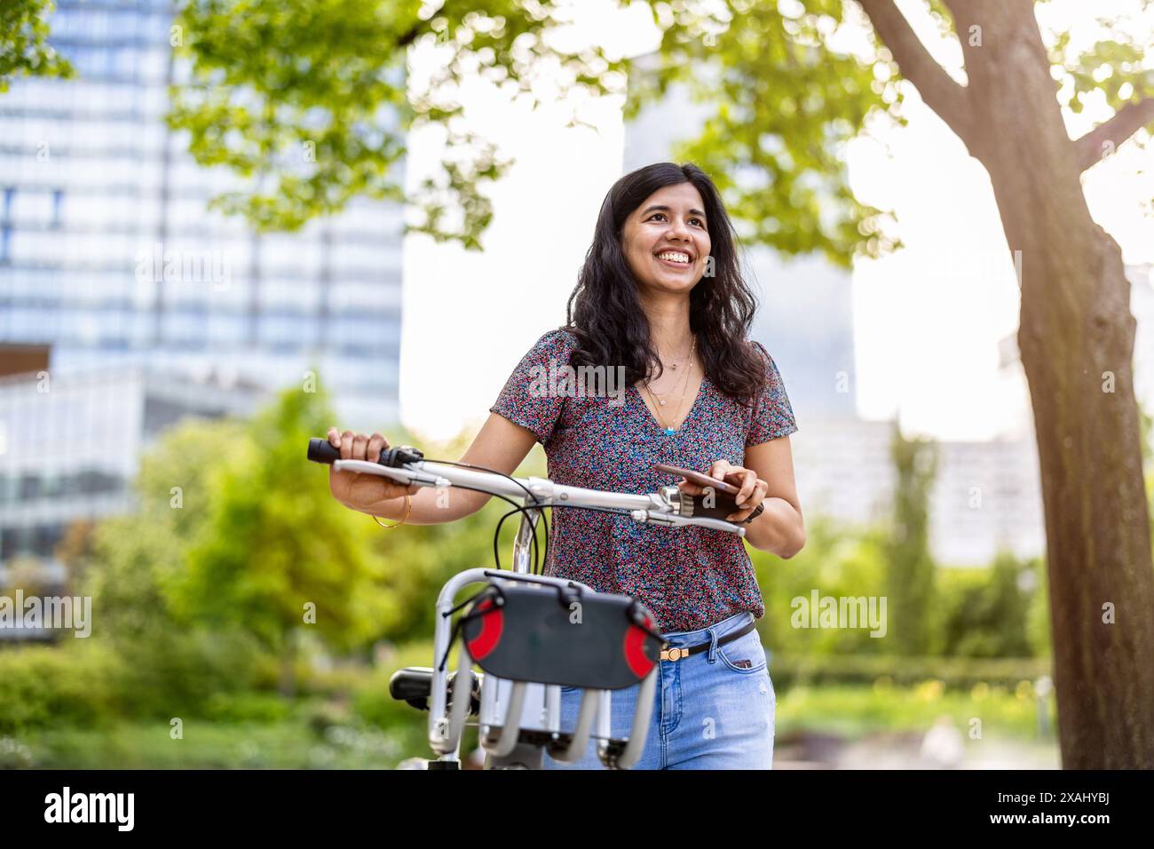 Ritratto di donna felice con la bicicletta in città Foto Stock