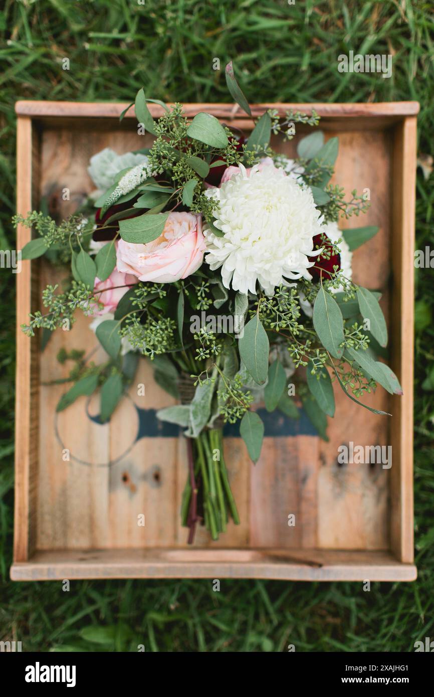 Bouquet di fiori nuziali con eucalipto adagiato su vassoio di legno Foto Stock