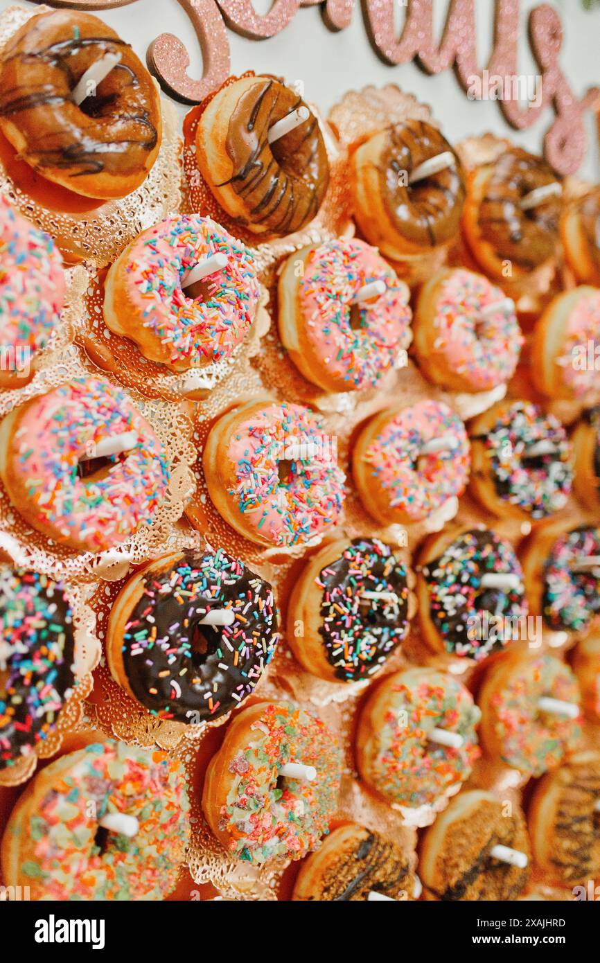 Spolverare ciambelle al matrimonio, ghiacciate al cioccolato Foto Stock