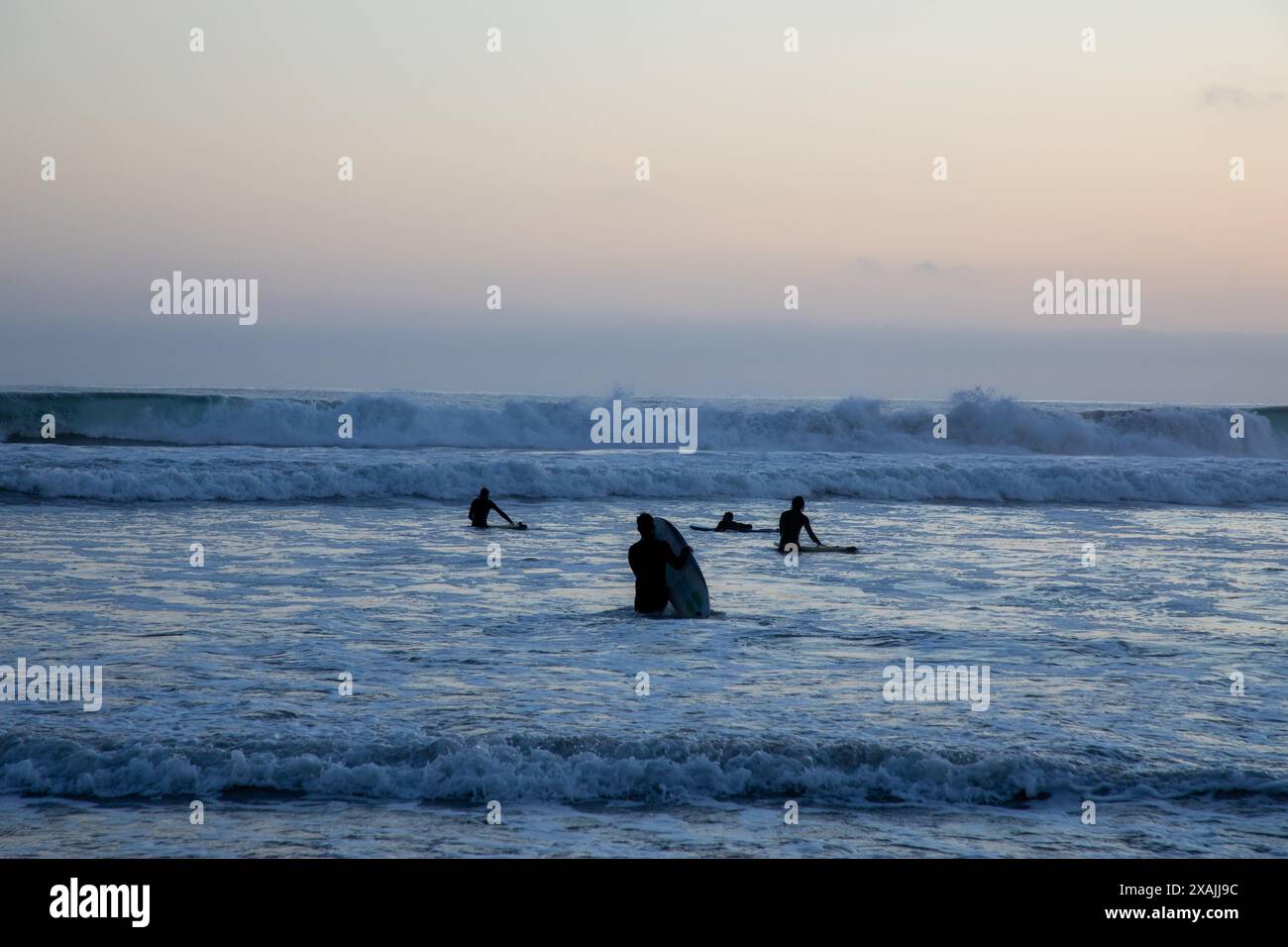 I surfisti aspettano le onde al crepuscolo a Oceanside, California Foto Stock