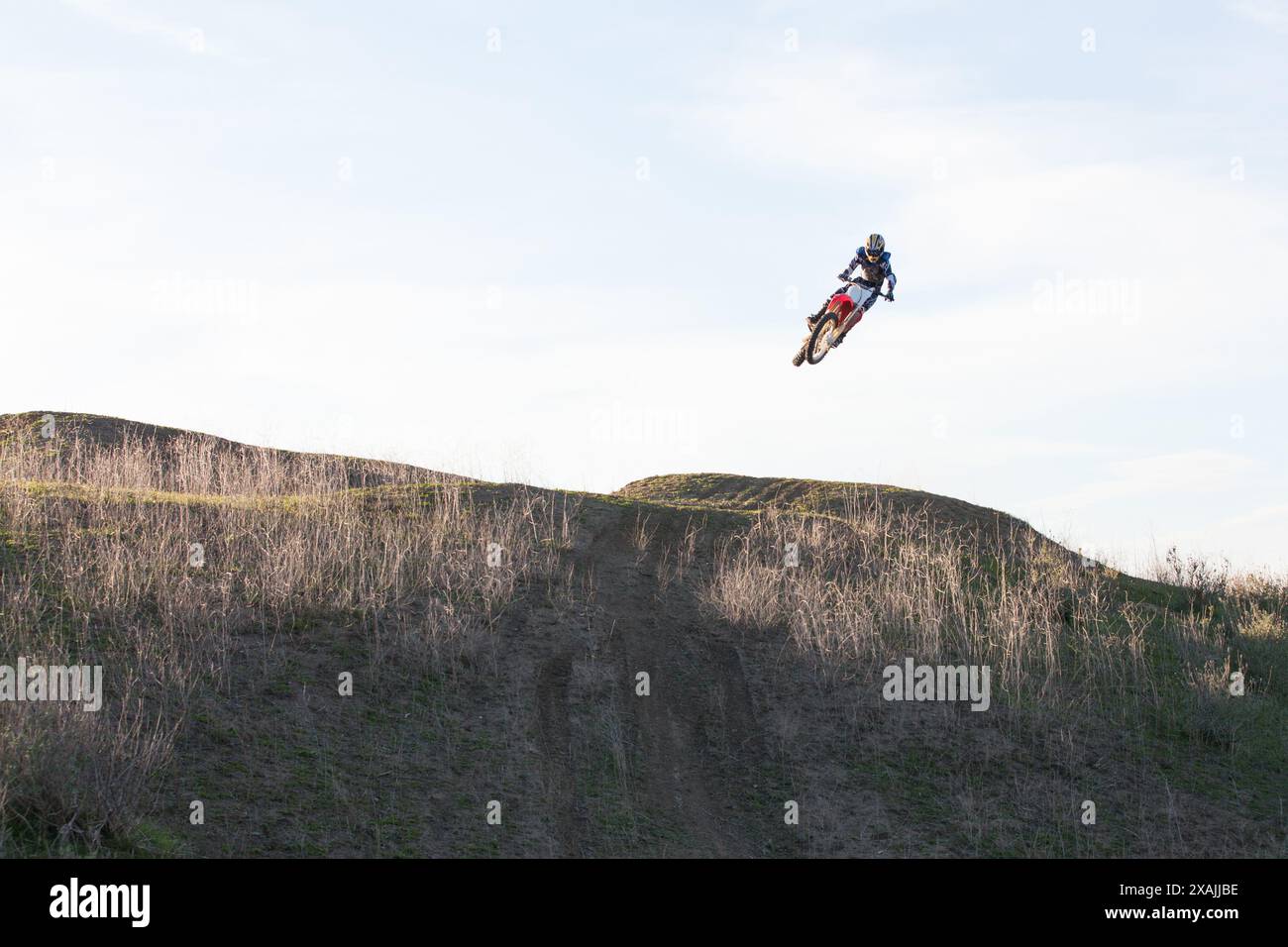 Abile motociclista che salta la sua bici sul sentiero. Foto Stock