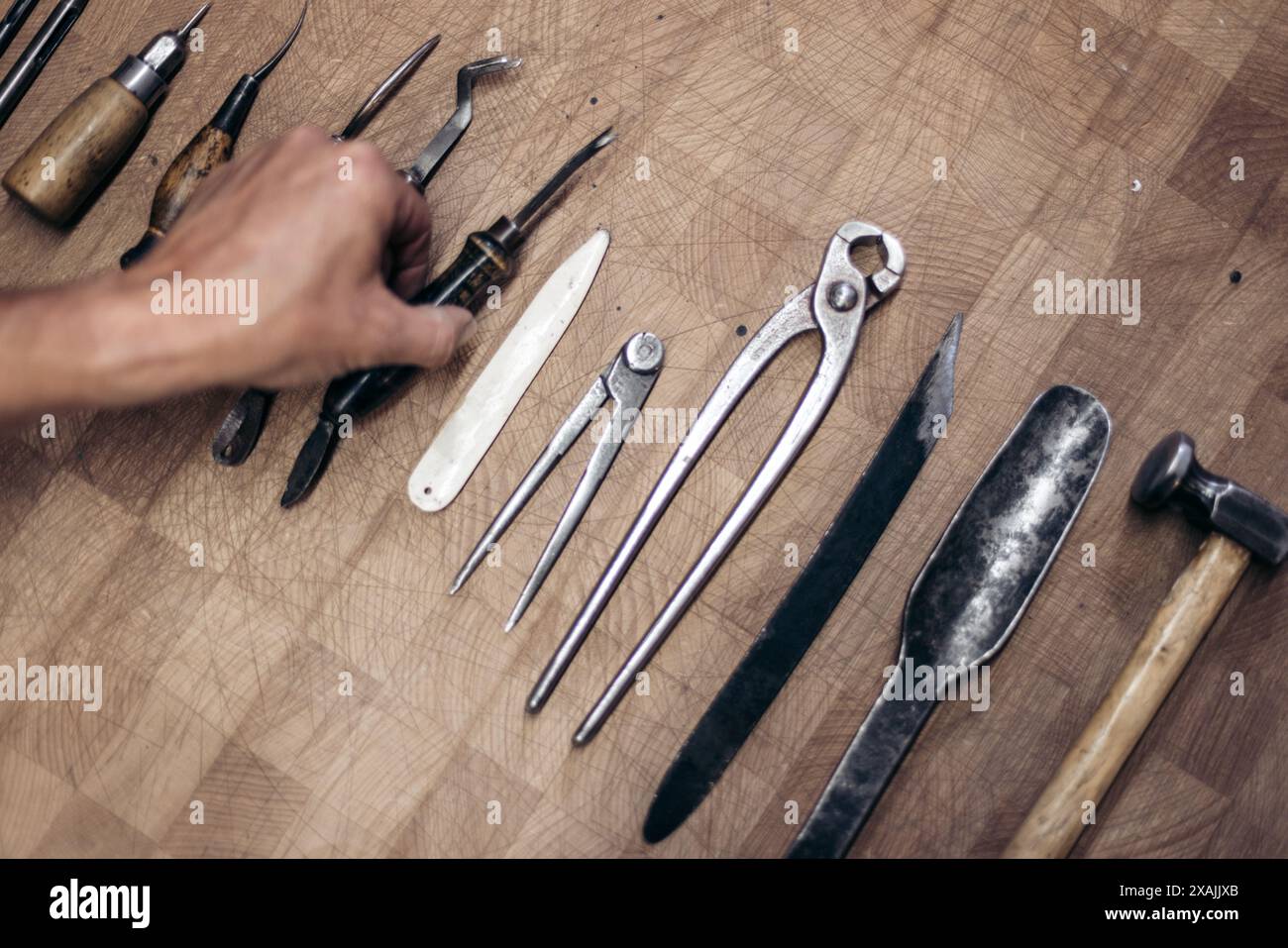 Gli utensili del calzolaio sono disposti su un banco di lavoro in legno Foto Stock