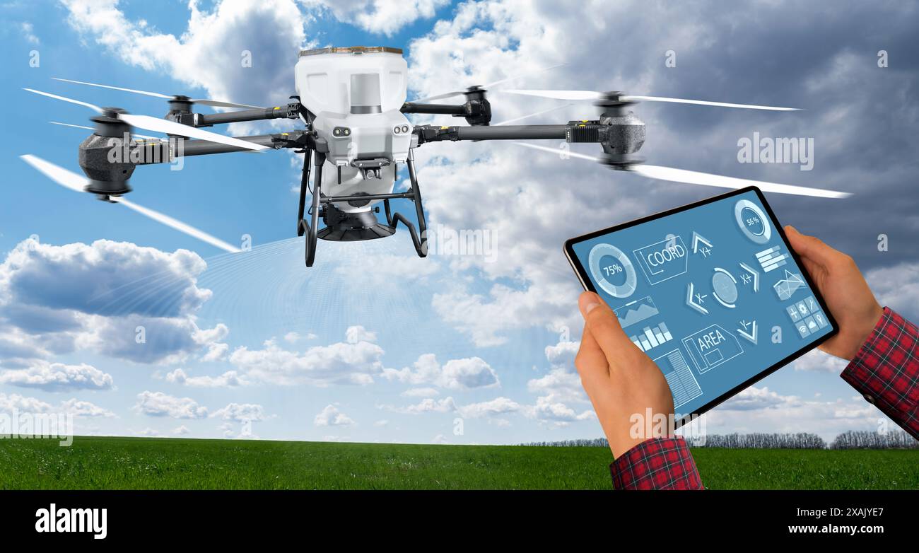 Agricoltore con tablet controlla lo spargimento di droni agricoli che diffondono fertilizzante. Agricoltura intelligente e agricoltura di precisione. Foto Stock