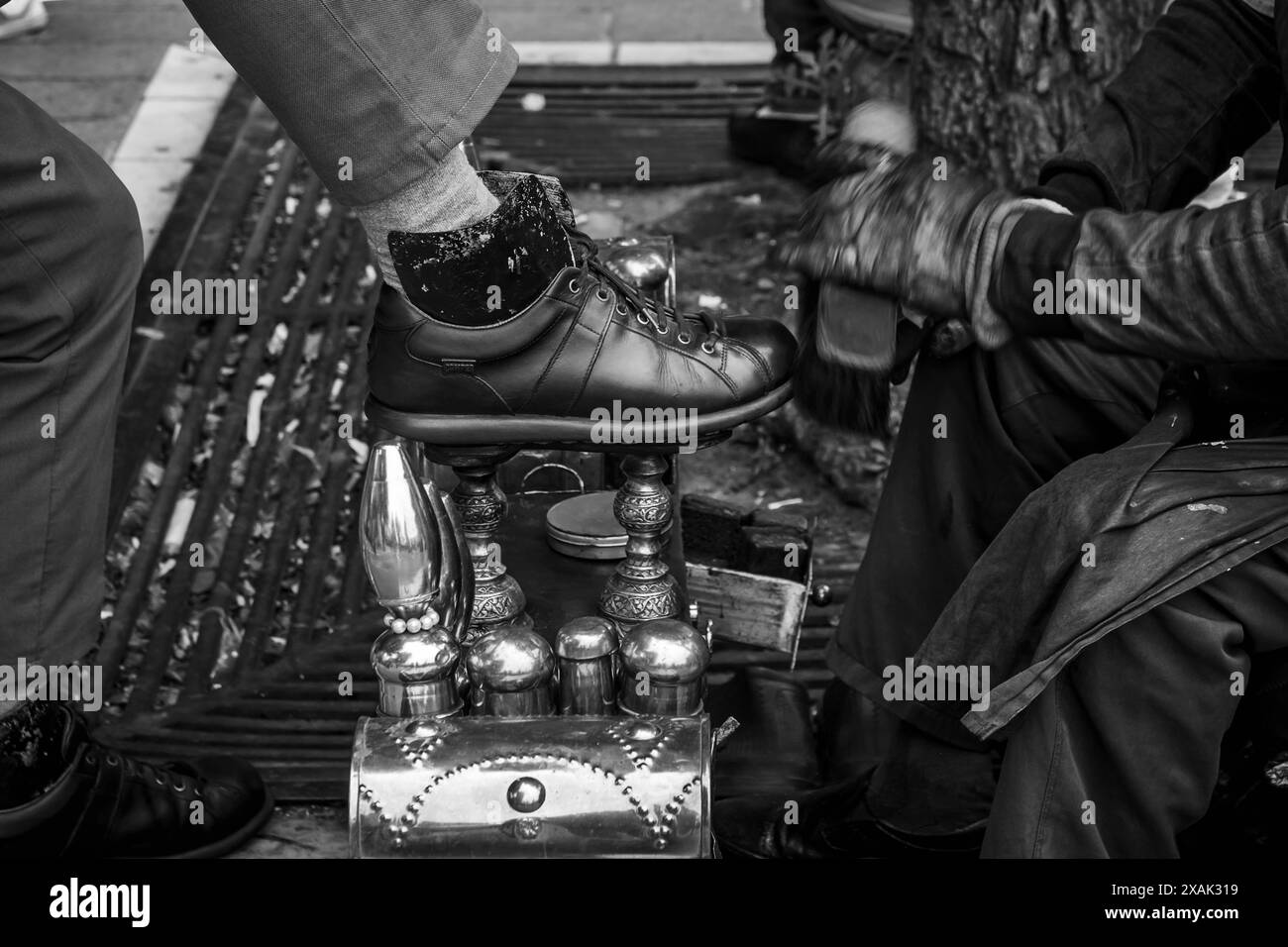 Una lavaparabrezza di Istanbul pulisce le scarpe di un cliente Foto Stock