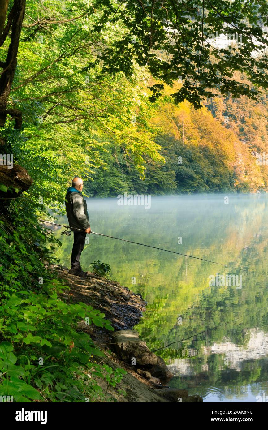 Il pescatore immerso nella natura selvaggia. Europa, Italia, Trentino alto Adige, non valle, provincia di Trento, città d'Anaunia, Tuenno. Foto Stock