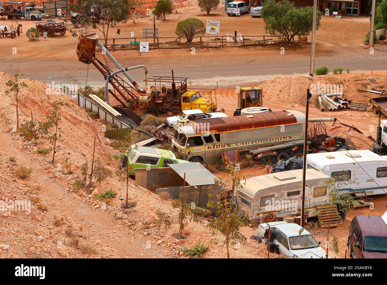 Vecchio camion soffiante in un deposito di auto d'epoca arrugginite abbandonate nel deserto dell'entroterra australiano del centro rosso nella città mineraria di opale di Co Foto Stock