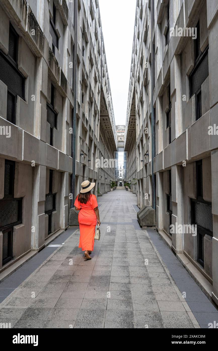 Nord America, Caraibi, isola di Hispaniola, Repubblica Dominicana, Santo Domingo, donna in abito estivo arancione a Faro a Colon Foto Stock