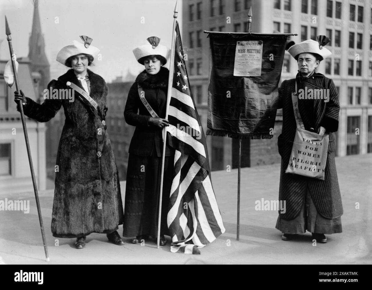 Suffragette con bandiera, tra c1910 e c1915. Mostra le donne escursioniste a suffragio, il generale Rosalie Jones, Jessie Stubbs e il colonnello Ida Craft, che indossa una borsa etichettata "Vota per le donne volantini di pellegrinaggio" e porta con sé uno striscione con un avviso per un "Partito del suffragio femminile". Riunione di massa. Teatro dell'opera. Brooklyn Academy of Music. Il 9 gennaio alle 20:15" con gli oratori Rev. Anna Shaw, Mrs. Carrie Chapman Catt e Max Eastman. Foto Stock