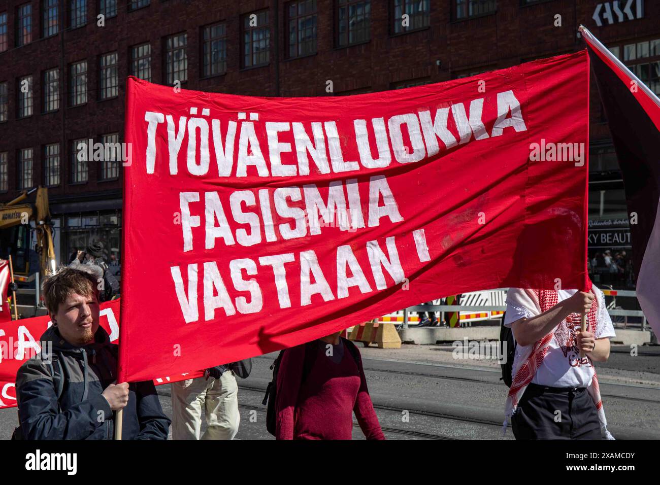 Työväenluokka fasismia vastaan! Striscione rosso alla marcia del Labor Day nel quartiere Hakaniemi di Helsinki, Finlandia. Foto Stock