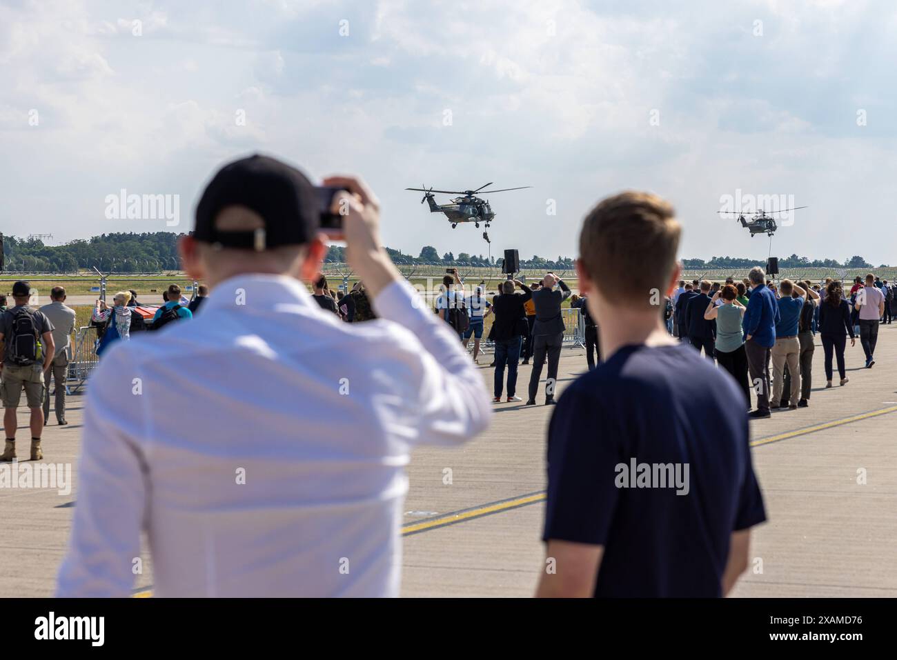 ILA 2024 - Berlin Deutschland, Berlin-Brandenburg Schönefeld AM 07.06.2024: Besucher der ILA schauen einer der vielen Flying Displays, hier der Bundeswehr Joint scenario - mit den CH-53, NH90, Tiger und H145M Hubschrauber. *** ILA 2024 Berlino Germania, Berlino Brandeburgo Schönefeld il 07 06 2024 i visitatori dell'ILA osservano una delle tante esposizioni volanti, qui lo scenario congiunto Bundeswehr con gli elicotteri CH 53, NH90, Tiger e H145M Foto Stock