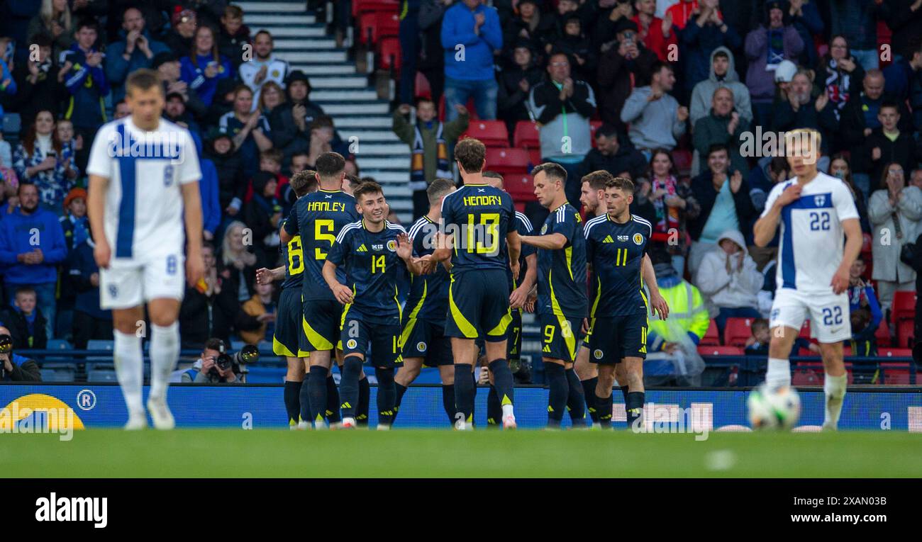 7 giugno 2024; Hampden Park, Glasgow, Scozia: Amichevole internazionale di calcio, Scozia contro Finlandia; i giocatori scozzesi festeggiano con Andy Robertson della Scozia dopo che la sua croce è stata trasformata in rete da Artu Hoskonen della Finlandia al 54 ° minuto per arrivare 1-0 in Scozia Foto Stock