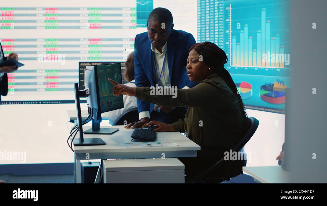 I dipendenti aziendali valutano gli indicatori chiave delle prestazioni all'interno dell'azienda, conducono valutazioni e discutono della situazione del flusso di lavoro. Lavoratori che migliorano la produttività e l'efficienza. Telecamera A.. Foto Stock