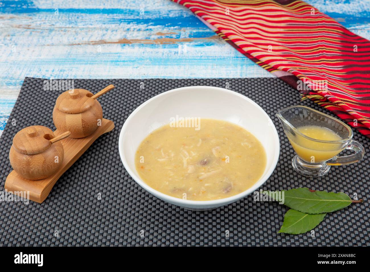 Zuppa di pesce in una ciotola. Zuppa di pesce con panna, salse, limone, erbe e crostini su fondo di legno. Foto Stock
