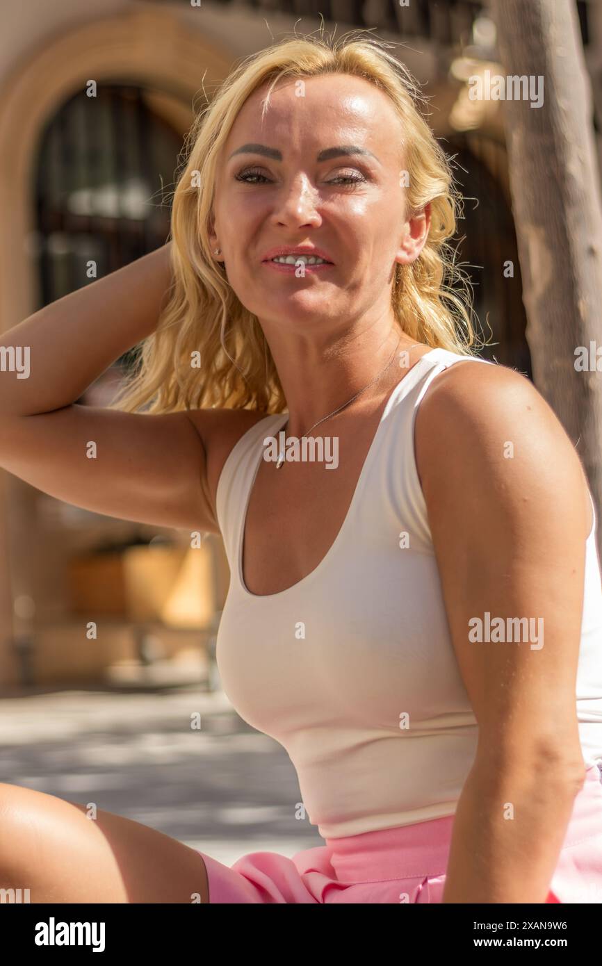 Questa accattivante immagine presenta un ritratto ravvicinato di una donna bionda con occhi verdi sorprendenti. Foto Stock