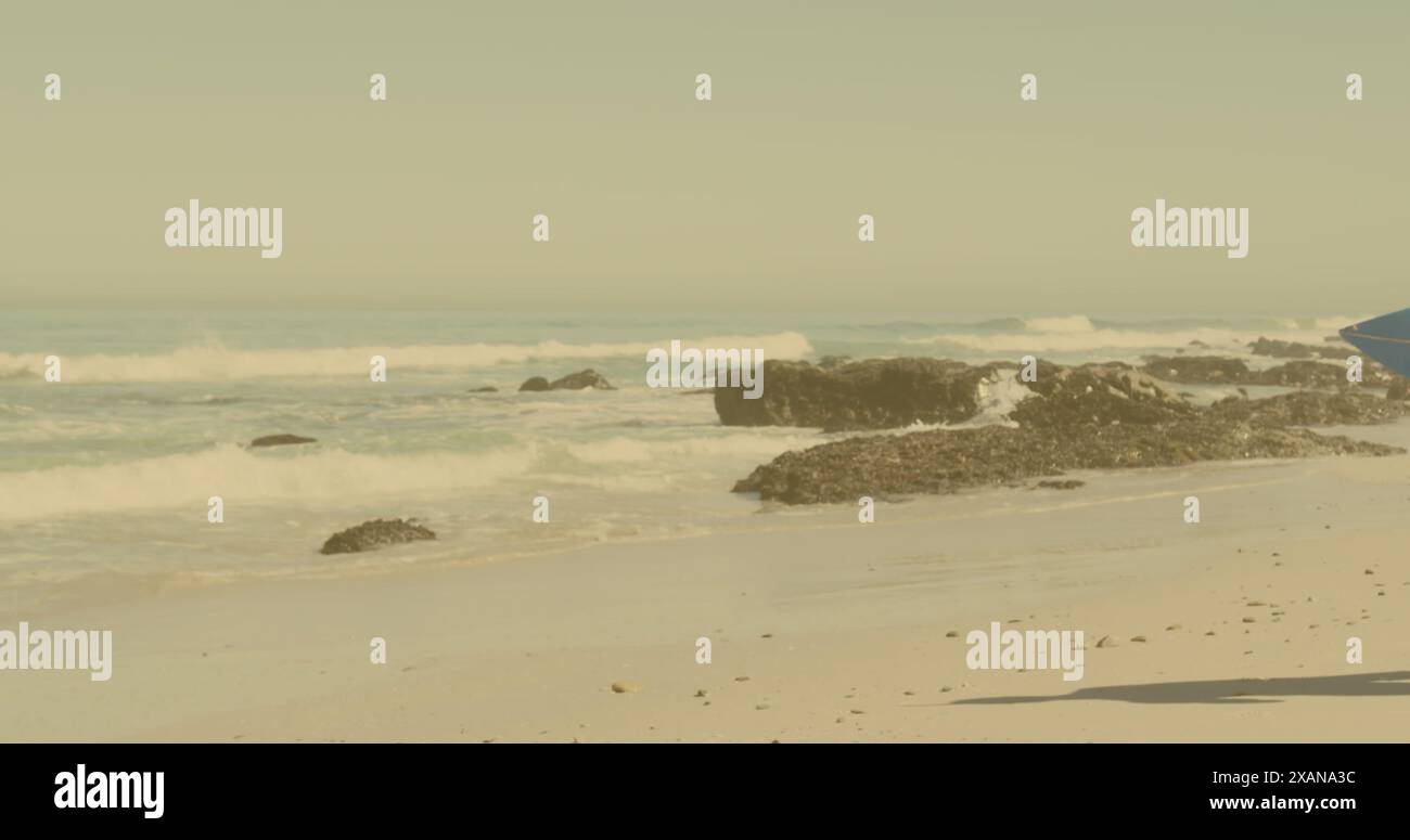 Immagine della luce sulla coppia afroamericana che cammina con tavole da surf sulla spiaggia Foto Stock