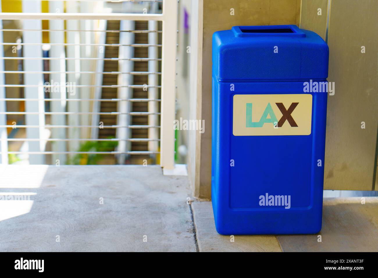 Los Angeles, California - 9 aprile 2024: Cestino dei rifiuti blu brillante nel parcheggio dell'aeroporto internazionale di Los Angeles (LAX), simbolo della pulizia e dell'ordine nella struttura. Foto Stock