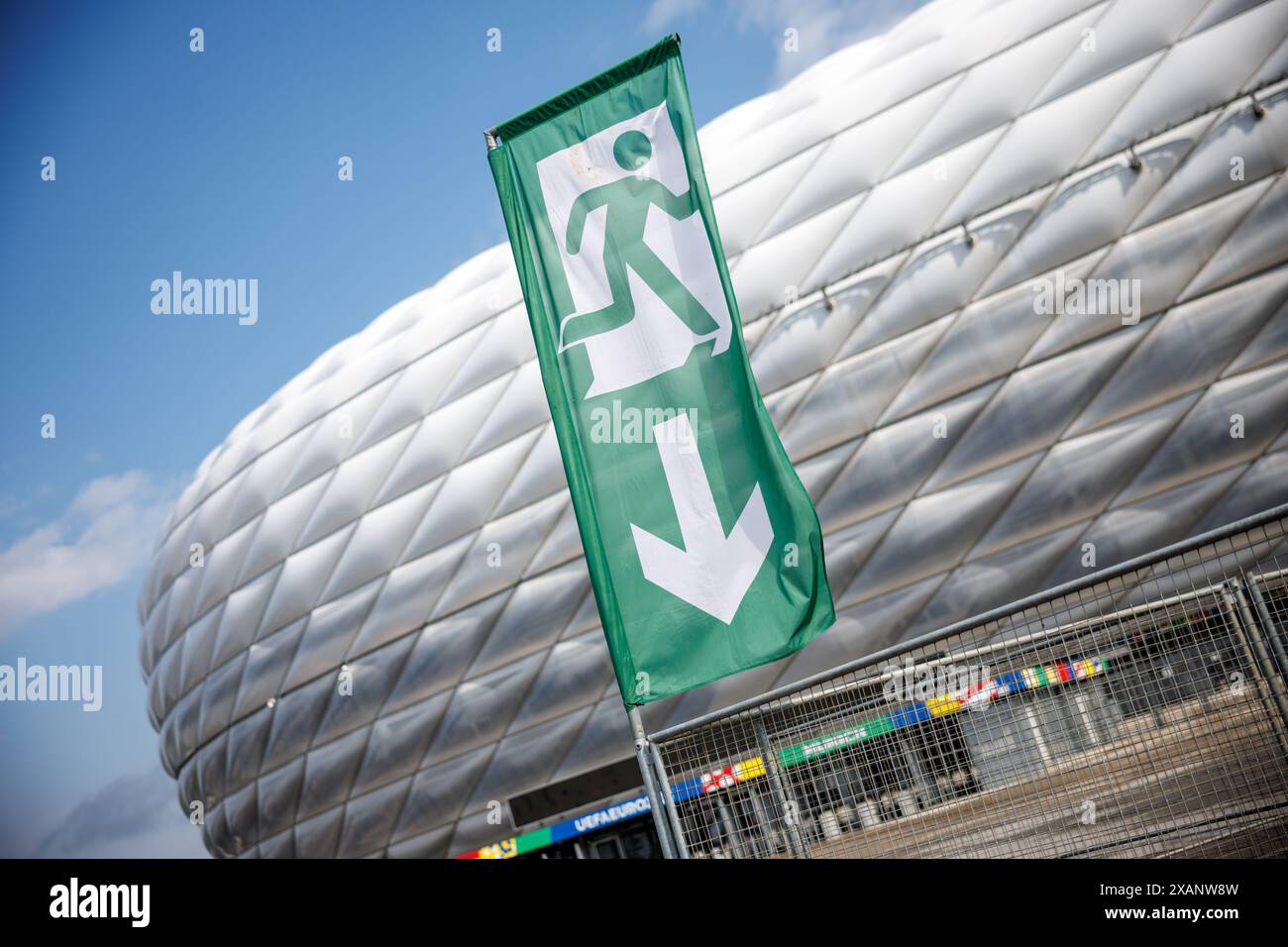 Monaco, Germania. 7 giugno 2024. Una bandiera con il simbolo di una via di fuga è visibile di fronte alla Munich Football Arena il 7 giugno 2024 in vista di una conferenza stampa per presentare il concetto di sicurezza per il Campionato europeo di calcio nella Munich Football Arena di Monaco (Baviera). Il campionato europeo di calcio prende il via nello stadio di calcio il 14 giugno con la partita di apertura Credit: Matthias Balk/dpa/Alamy Live News Foto Stock