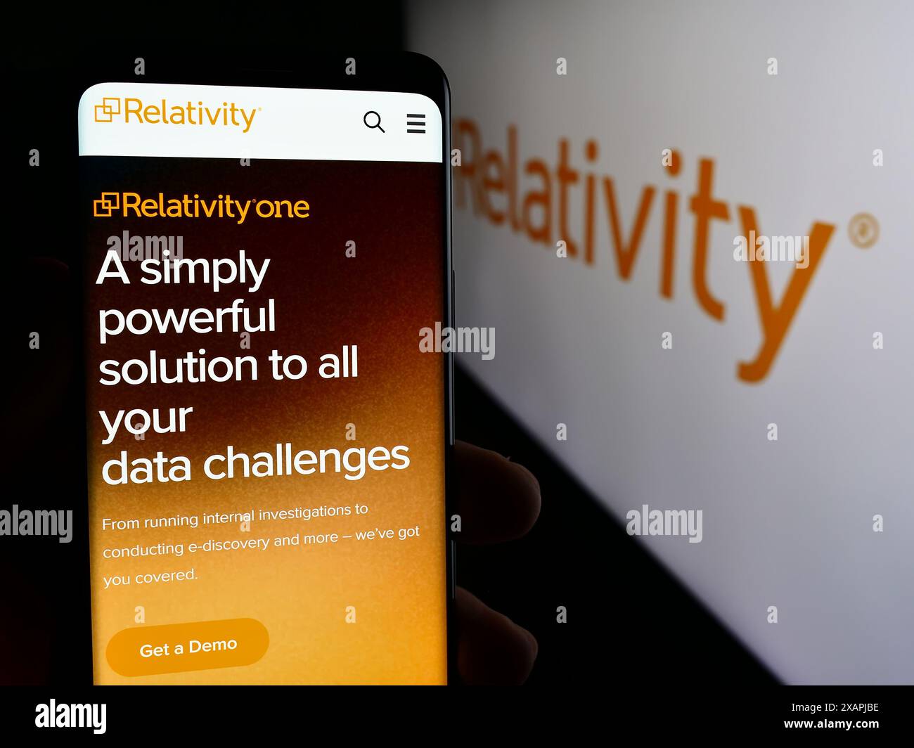 Persona che detiene lo smartphone con la pagina Web della società di software di e-Discovery statunitense Relativity ODA LLC davanti al logo. Messa a fuoco al centro del display del telefono. Foto Stock