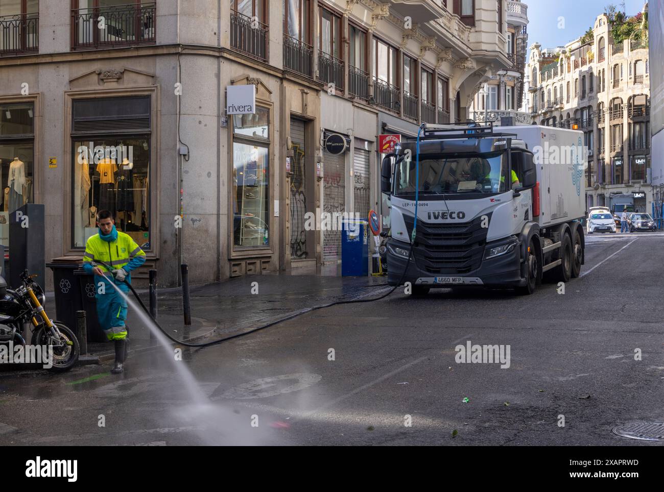 Domenica mattina acqua a getto di pressione pulizia stradale municipale, centro di Madrid, Spagna Foto Stock