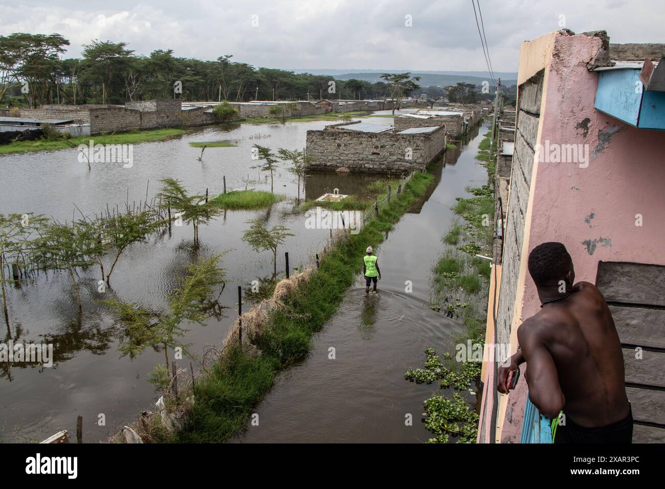 7 giugno 2024, Nakuru, Kenya: Un uomo cammina attraverso un'area allagata a seguito dell'innalzamento del livello dell'acqua del lago Naivasha nella contea di Nakuru. L'innalzamento dei livelli del lago Naivasha ha sfollato oltre 5.000 persone nella Kihoto Estate, a circa 90 km a nord-ovest di Nairobi, la capitale del Kenya. Le loro case sono state sommerse a causa dell'aumento delle precipitazioni negli ultimi due mesi, che ha portato all'aumento del livello dell'acqua del lago. Il Kenya Meteorological Department ha previsto che altre piogge continueranno a cadere e la situazione delle inondazioni potrebbe aggravarsi. (Immagine di credito: © James Wakibia/SOPA Images via ZUMA Press Wire) EDI Foto Stock