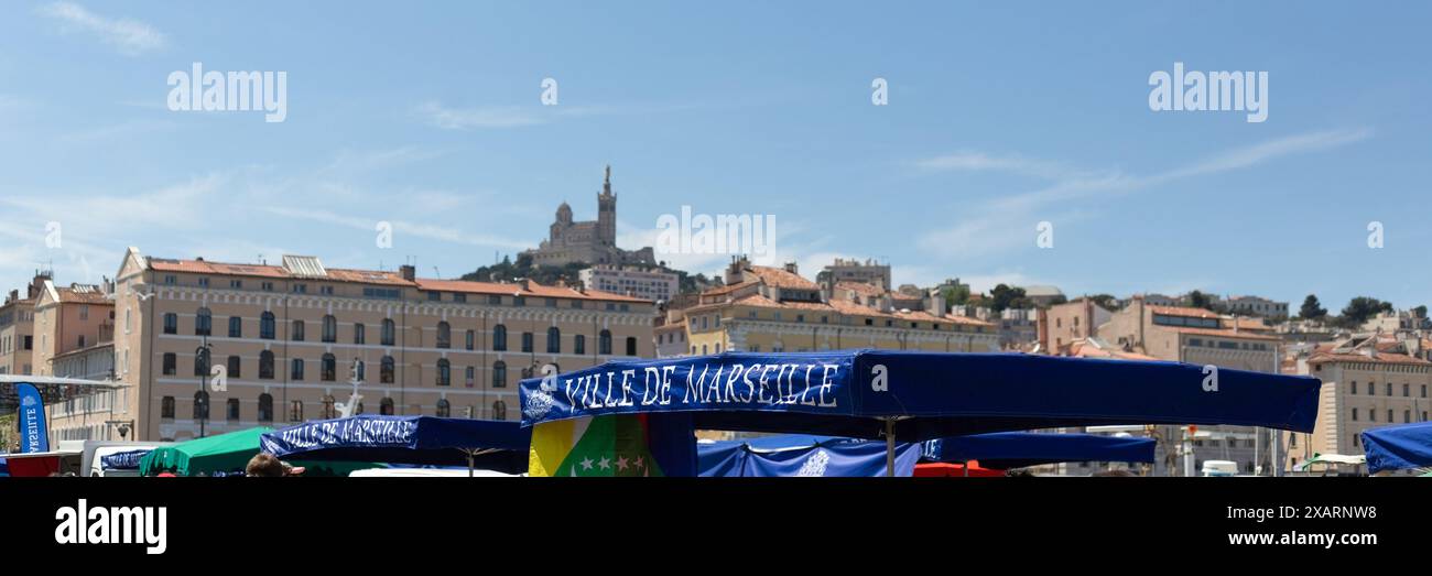 MARSIGLIA, FRANCIA - 19 MAGGIO 2024: Barca da pesca tradizionale sulla banchina del Porto Vecchio con la Basilica di Notre-Dame de la Garde sullo sfondo Foto Stock