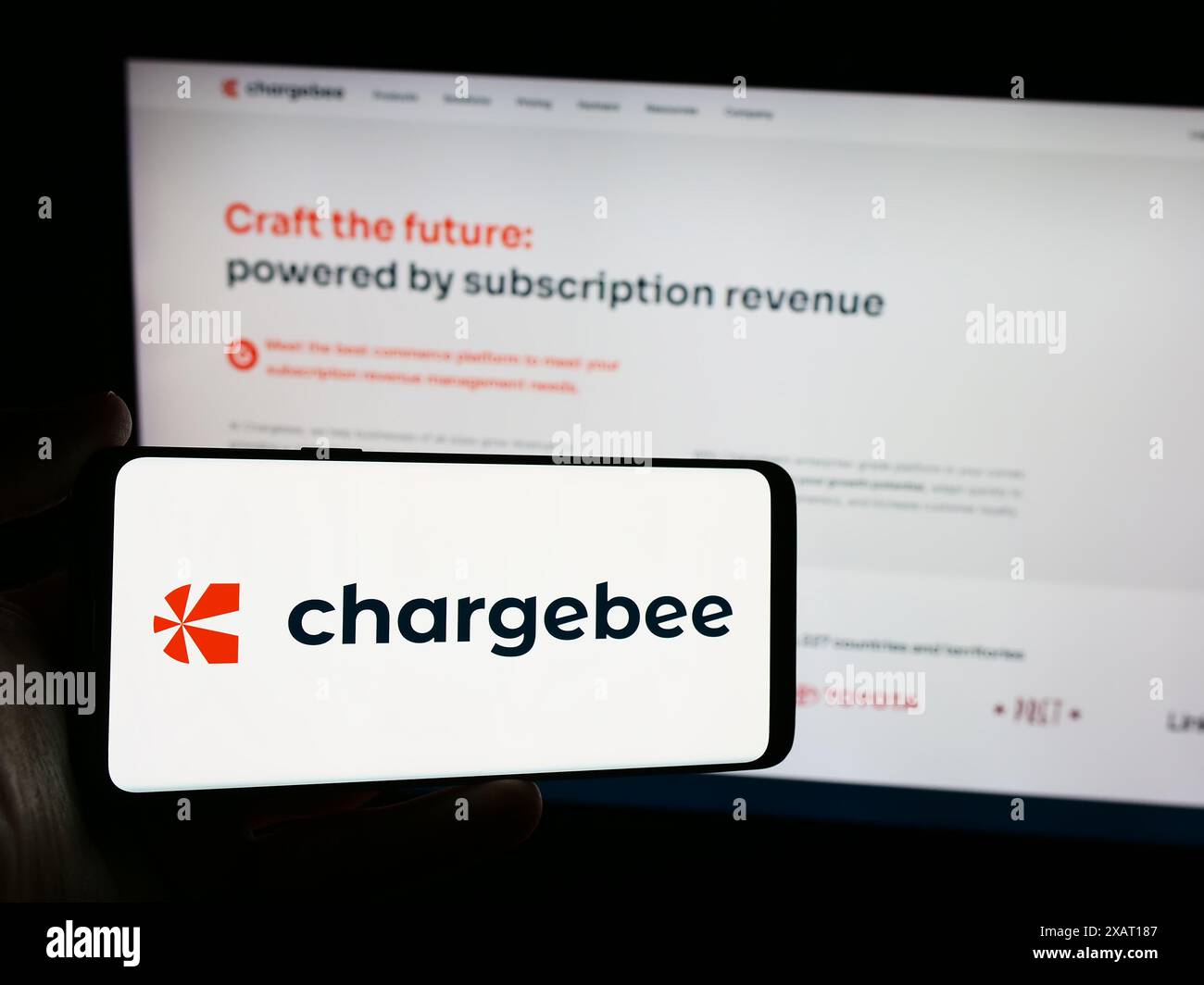 Persona che detiene uno smartphone con il logo della società statunitense Chargebee Inc. Di fronte al sito Web. Mettere a fuoco il display del telefono. Foto Stock