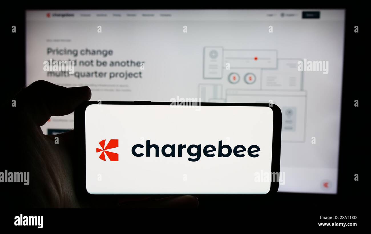 Persona che detiene un cellulare con il logo della società statunitense Chargebee Inc. Di fronte alla pagina Web aziendale. Mettere a fuoco il display del telefono. Foto Stock
