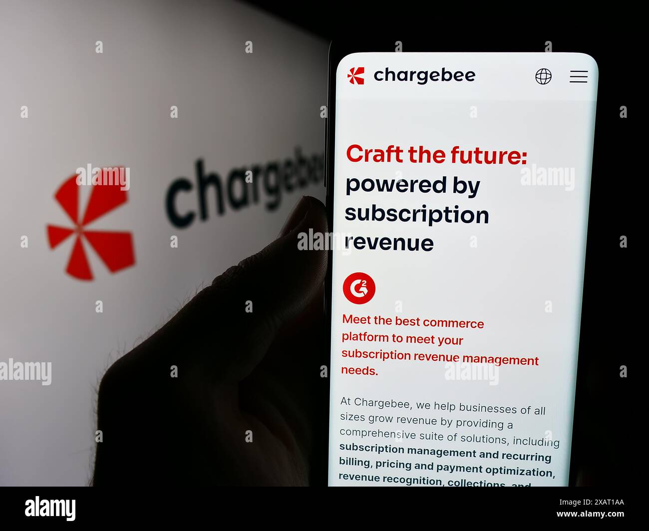 Persona che detiene un cellulare con pagina web della società statunitense Chargebee Inc. Di fronte al logo. Messa a fuoco al centro del display del telefono. Foto Stock