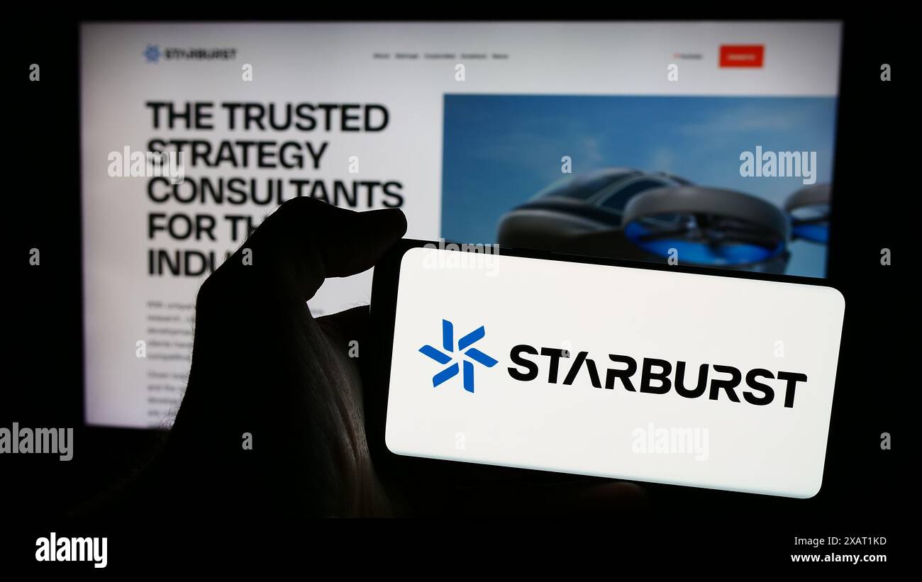 Persona che detiene un telefono cellulare con il logo della società americana di venture capital Starburst Aerospace Ltd. Di fronte alla pagina Web. Mettere a fuoco il display del telefono. Foto Stock