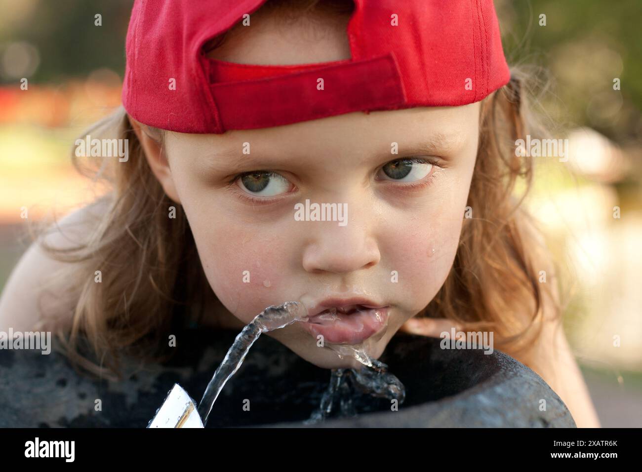 primo piano di una bambina che beve dalla fontana Foto Stock