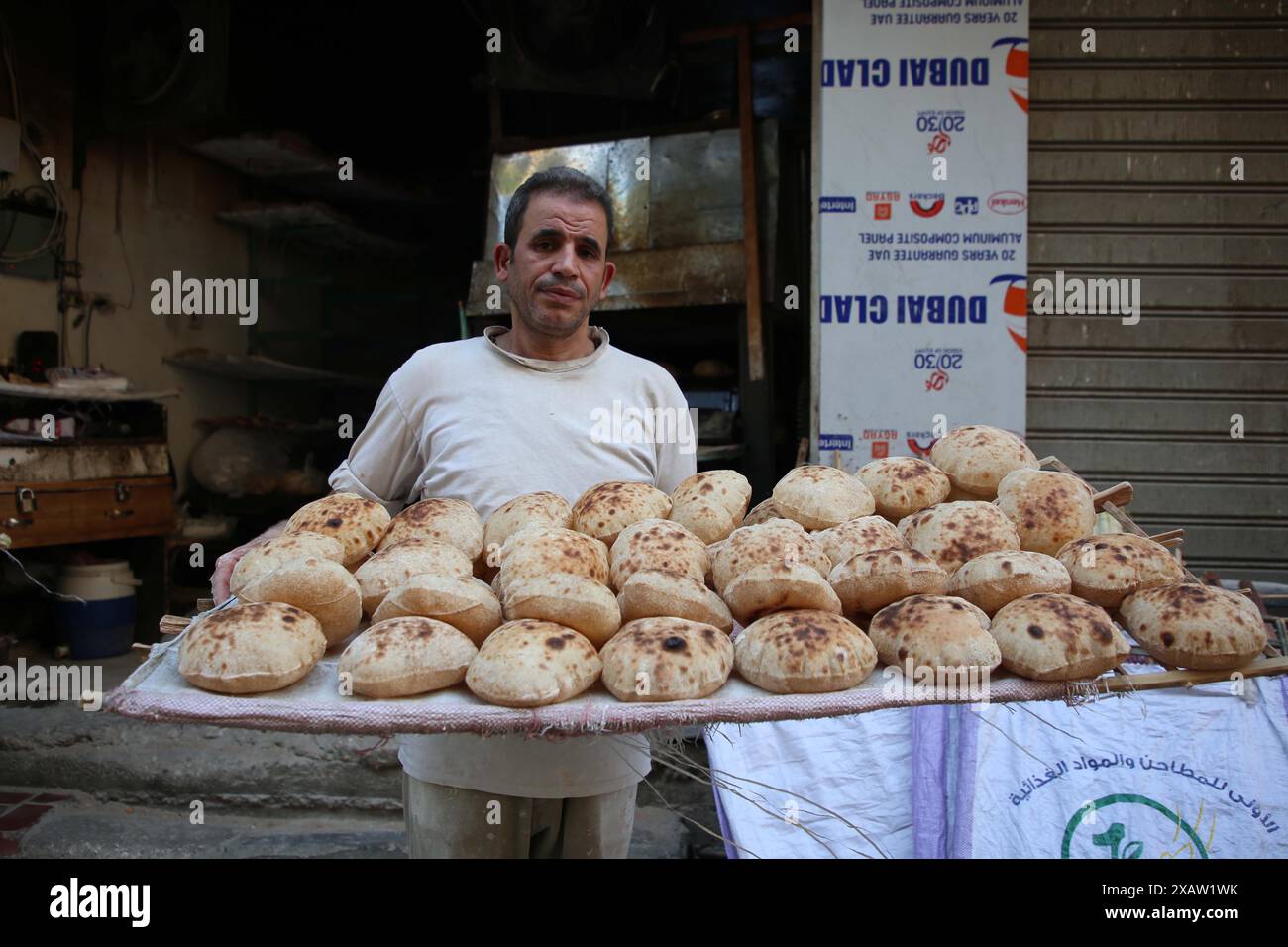 Cairo, Egitto. 7 giugno 2024. Un panettiere presenta il pane per la vendita in una panetteria del Cairo, Egitto, 7 giugno 2024. PER ANDARE AVANTI CON "News Analysis: Egypt adotta tagli senza precedenti sulla sovvenzione del pane per ridurre il deficit di bilancio" credito: Ahmed Gomaa/Xinhua/Alamy Live News Foto Stock