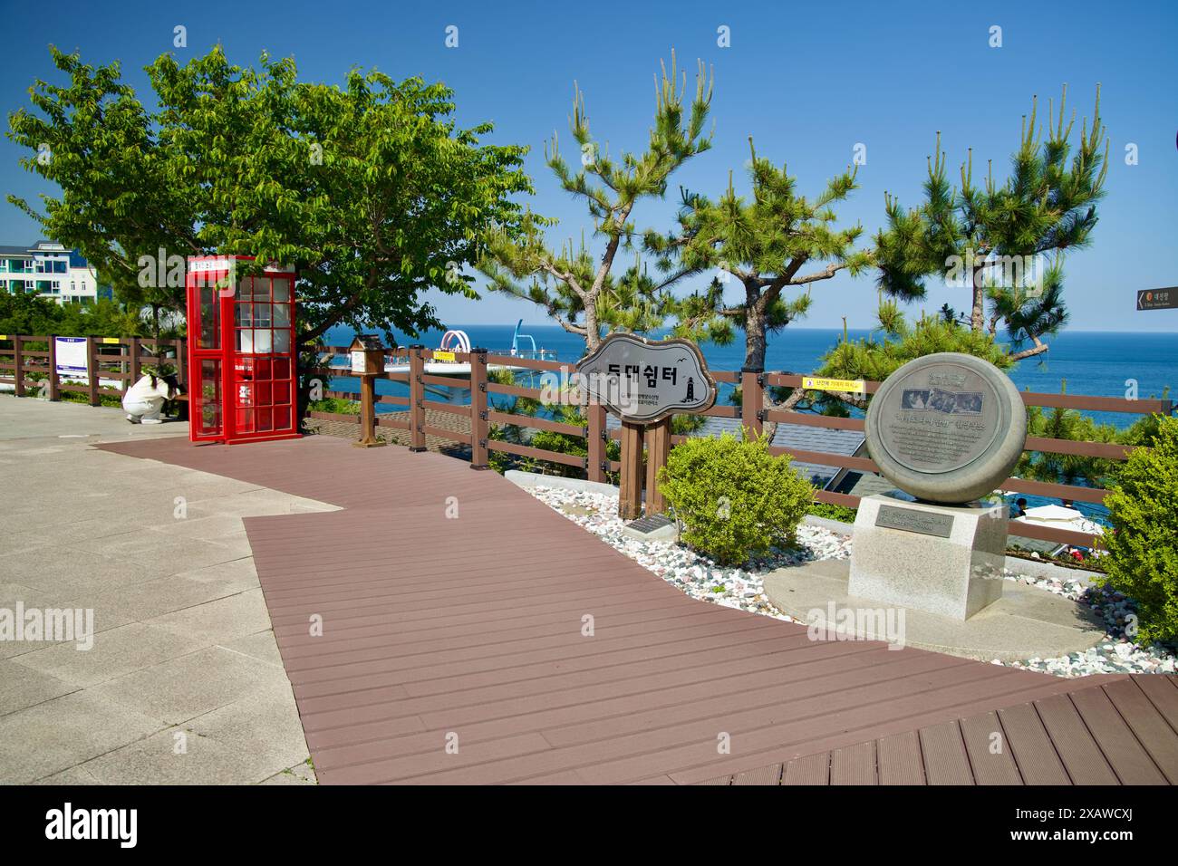 Donghae, Corea del Sud - 18 maggio 2024: Il cortile del faro di Mukho presenta cartelli storici, una cabina telefonica rossa e viste panoramiche della East se Foto Stock
