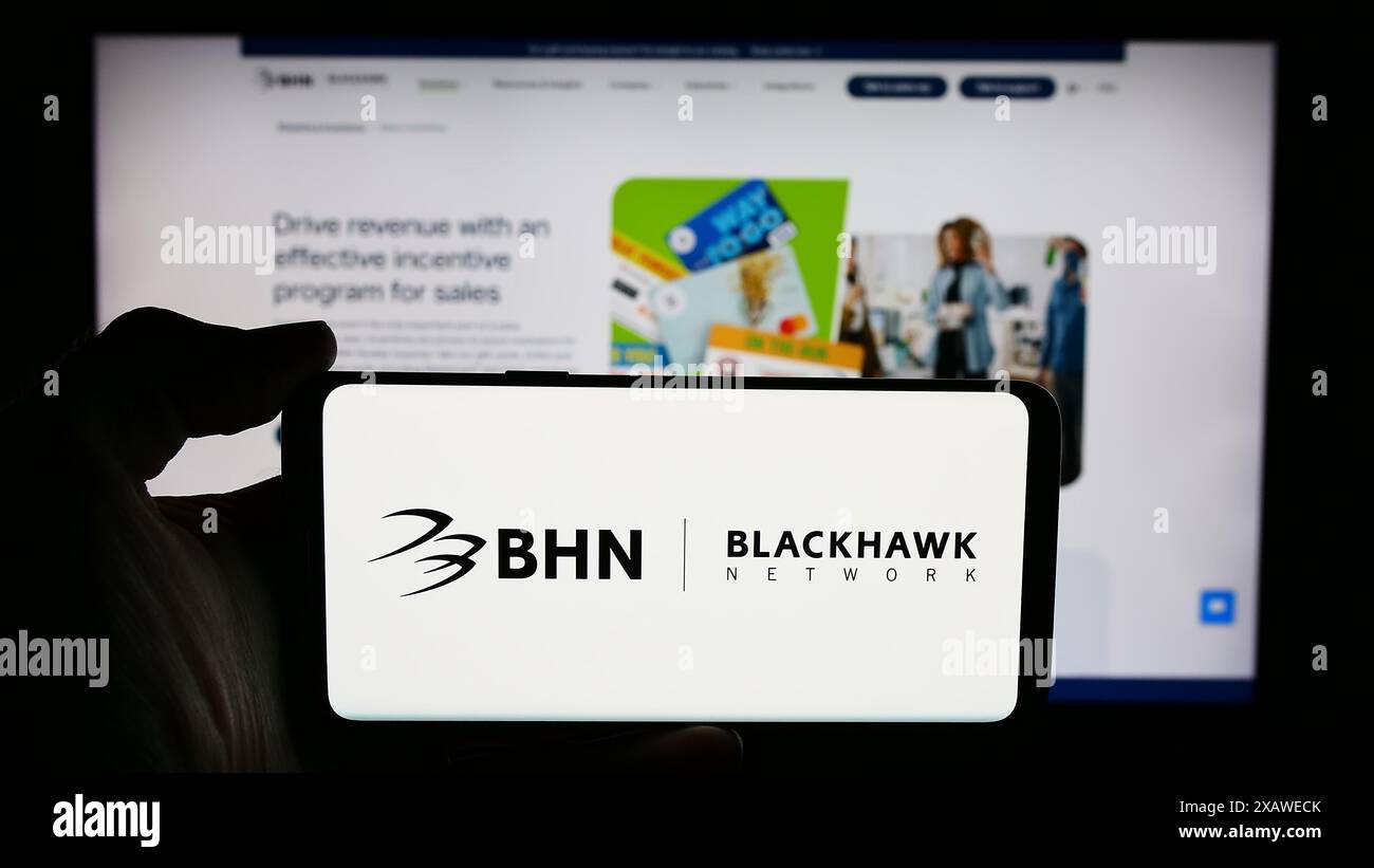 Persona che detiene un cellulare con il logo della società di soluzioni di pagamento Blackhawk Network Holdings Inc. Davanti alla pagina Web. Mettere a fuoco il display del telefono. Foto Stock