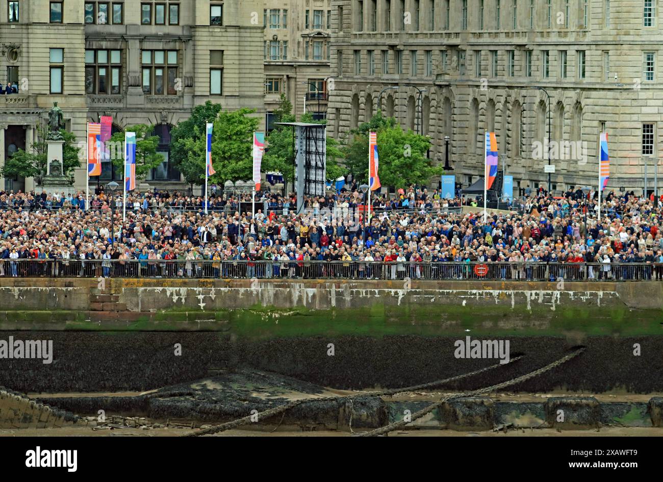 Folle di persone sul molo si dirigono a Liverpool osservando la nuova nave da crociera di Cunard "Queen Anne" che si dirige verso il fiume Mersey per essere ufficialmente nominata Foto Stock
