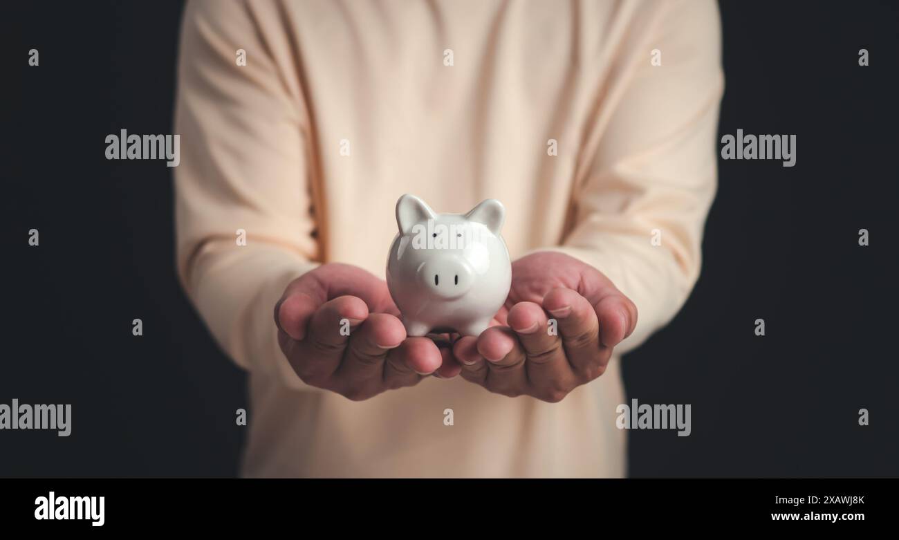 Un uomo che detiene il salvadanaio bianco per il concetto di risparmio di denaro, concetto di risparmio di denaro, risparmio per investimenti, banche, prestiti, prestito a domicilio, pianificazione finanziaria, Foto Stock