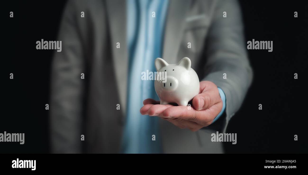 Uomo d'affari che detiene il salvadanaio bianco per il concetto di risparmio di denaro, concetto di risparmio di denaro, risparmio per investimenti, banche, prestiti, prestito casa, piano finanziario Foto Stock