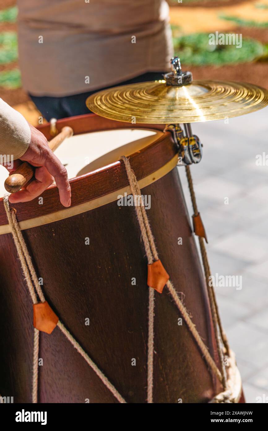 Dettaglio delle mani che tengono le bacchette di batteria suonano timpani e tamburi piatti in una processione della popolare band che sfilano attraverso il popolare festival floreale o Foto Stock