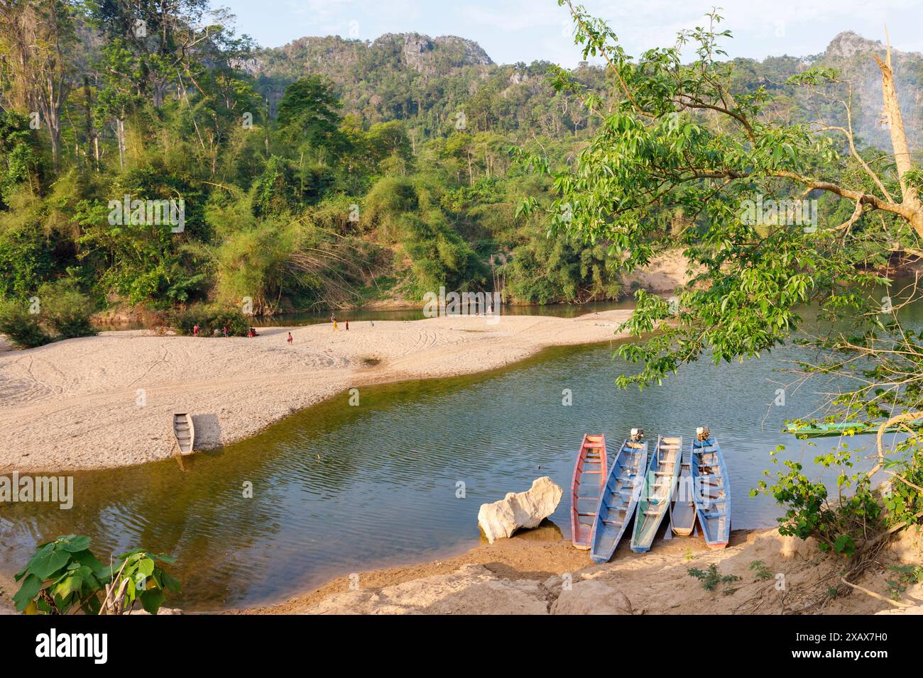 Barche in riva con bambini che giocano in lontananza, fiume XE Bang fai, Laos Foto Stock