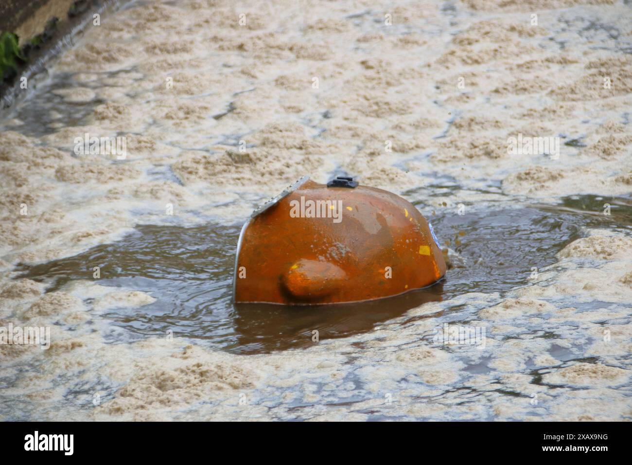 Il casco di un subacqueo guarda fuori da una piscina in un impianto di depurazione Foto Stock